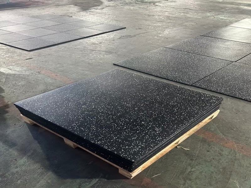 A professional installer using a long level to check the flatness of a concrete subfloor before flooring installation.